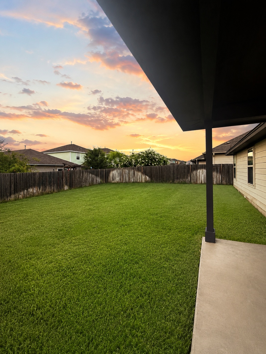 187 Limerick Road Buda, TX 78610 - Photo 17 of 18 Discover a tranquil outdoor retreat with a manicured lawn, secure fencing, and a covered patio perfect for evening relaxation.