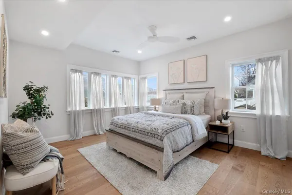 a bedroom with a large bed and wooden floor