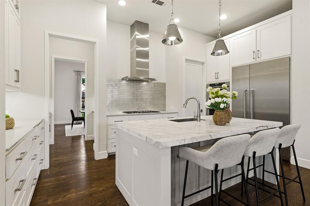 6523 Northwood Road Dallas, TX 75225 - Photo 12 of 36 a kitchen with stainless steel appliances kitchen island granite countertop a kitchen island and chairs in it