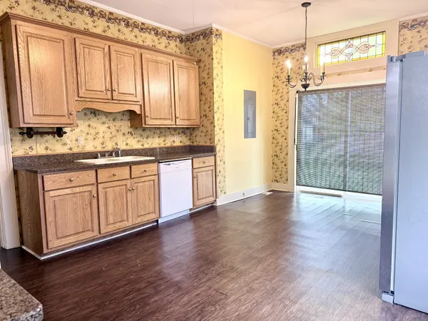 a view of a kitchen with granite countertop a stove a sink and dishwasher with wooden floor