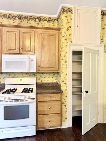a kitchen with granite countertop white cabinets and white appliances