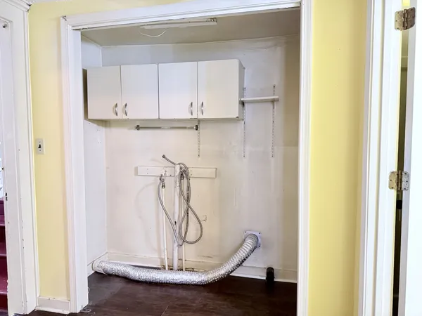 a view of a room with wooden floor and cabinets