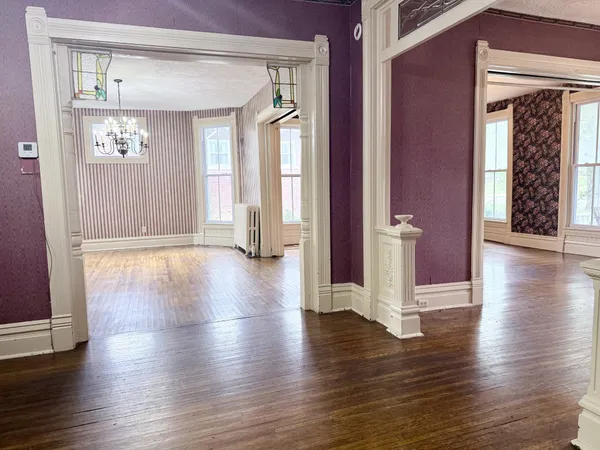 a view of a hallway with wooden floor and closet