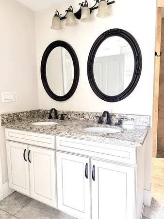 a bathroom with a granite countertop sink and a mirror
