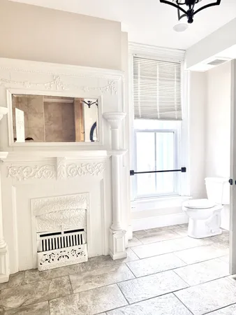 a view of a livingroom with a fireplace and a window