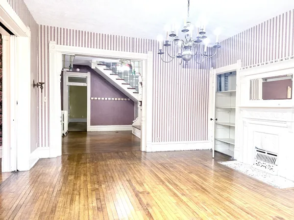 a view of a hallway with wooden floor and staircase