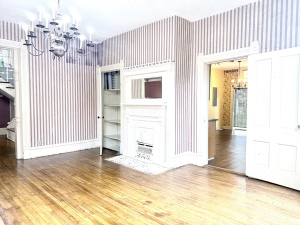 a view of a livingroom with wooden floor and a large window