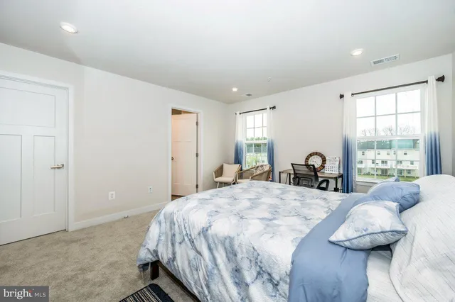 a bedroom with a bed and glass windows