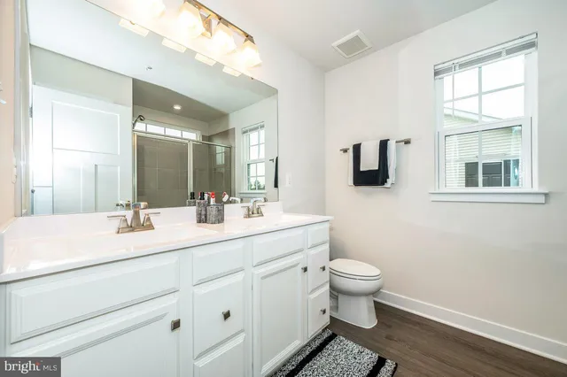 a bathroom with a double vanity sink toilet and mirror