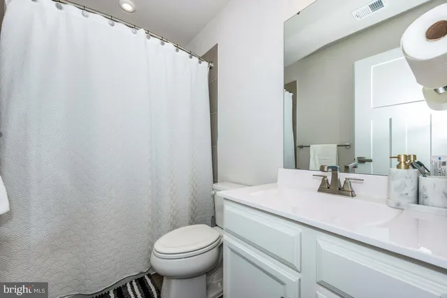 a bathroom with a sink a toilet and mirror