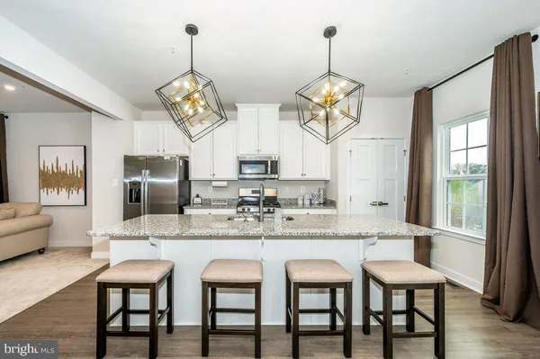 a dining room with stainless steel appliances granite countertop furniture a fireplace and kitchen view