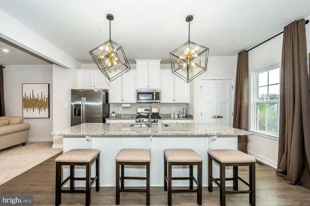 a dining room with stainless steel appliances granite countertop furniture a fireplace and kitchen view
