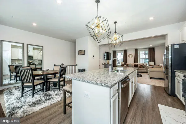 a view of a dining room and livingroom with furniture wooden floor a chandelier