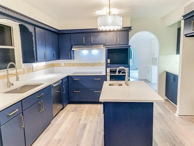 a kitchen with a sink stainless steel appliances and cabinets