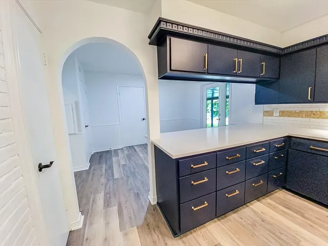 a kitchen with a wooden floor and cabinets