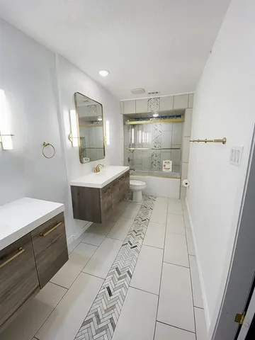 a large white kitchen with a sink stainless steel appliances and cabinets