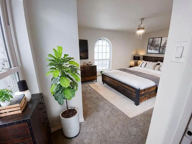 a bed room with a bed and a potted plant