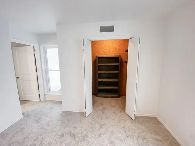 an empty room with a stove and a refrigerator