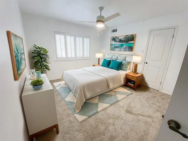 a bedroom with a bed window and potted plant