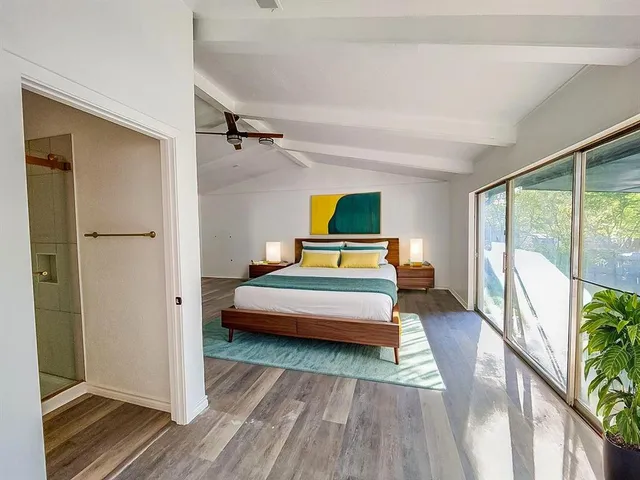 a bedroom with a bed and wooden floor