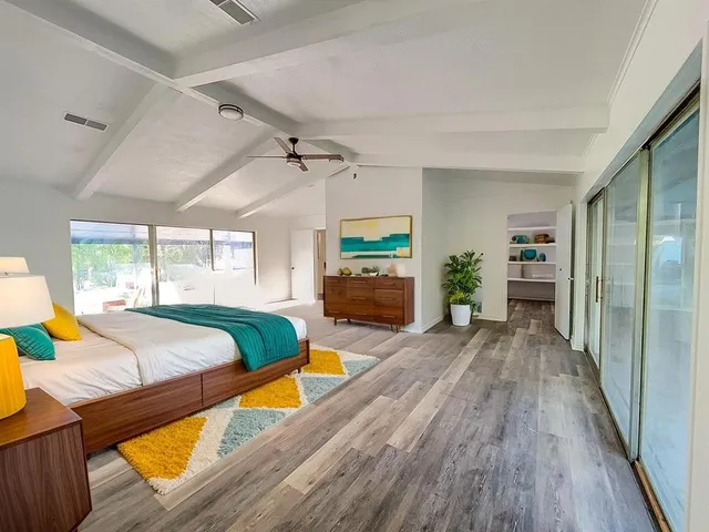 a spacious bedroom with a bed and a wooden floor