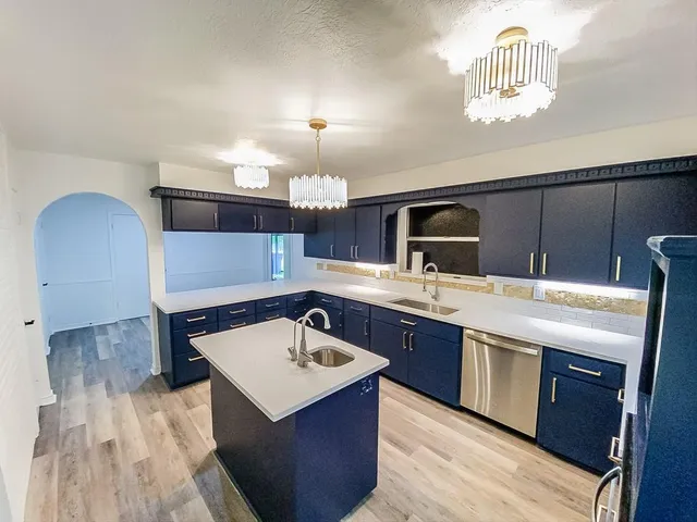 a kitchen with a sink cabinets and wooden floor
