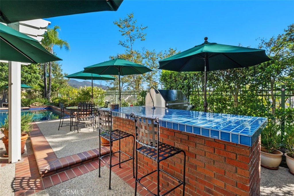 6 Muirfield Rancho Santa Margarita, CA 92679 - Photo 33 of 49 a patio with tables and chairs under an umbrella