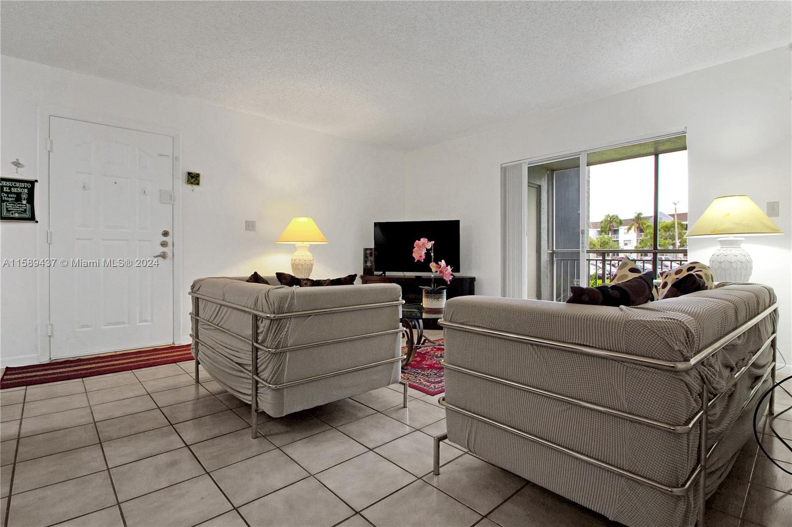 8650 Southwest 212th Street, Unit 101 Cutler Bay, FL 33189 - Photo 24 of 29 a living room with furniture and a lamp