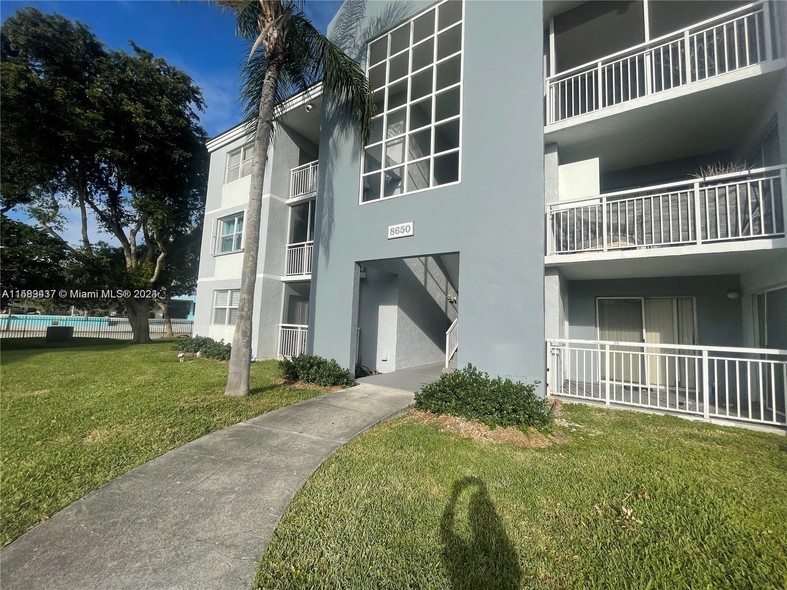 8650 Southwest 212th Street, Unit 101 Cutler Bay, FL 33189 - Photo 3 of 29 a front view of a house with a yard