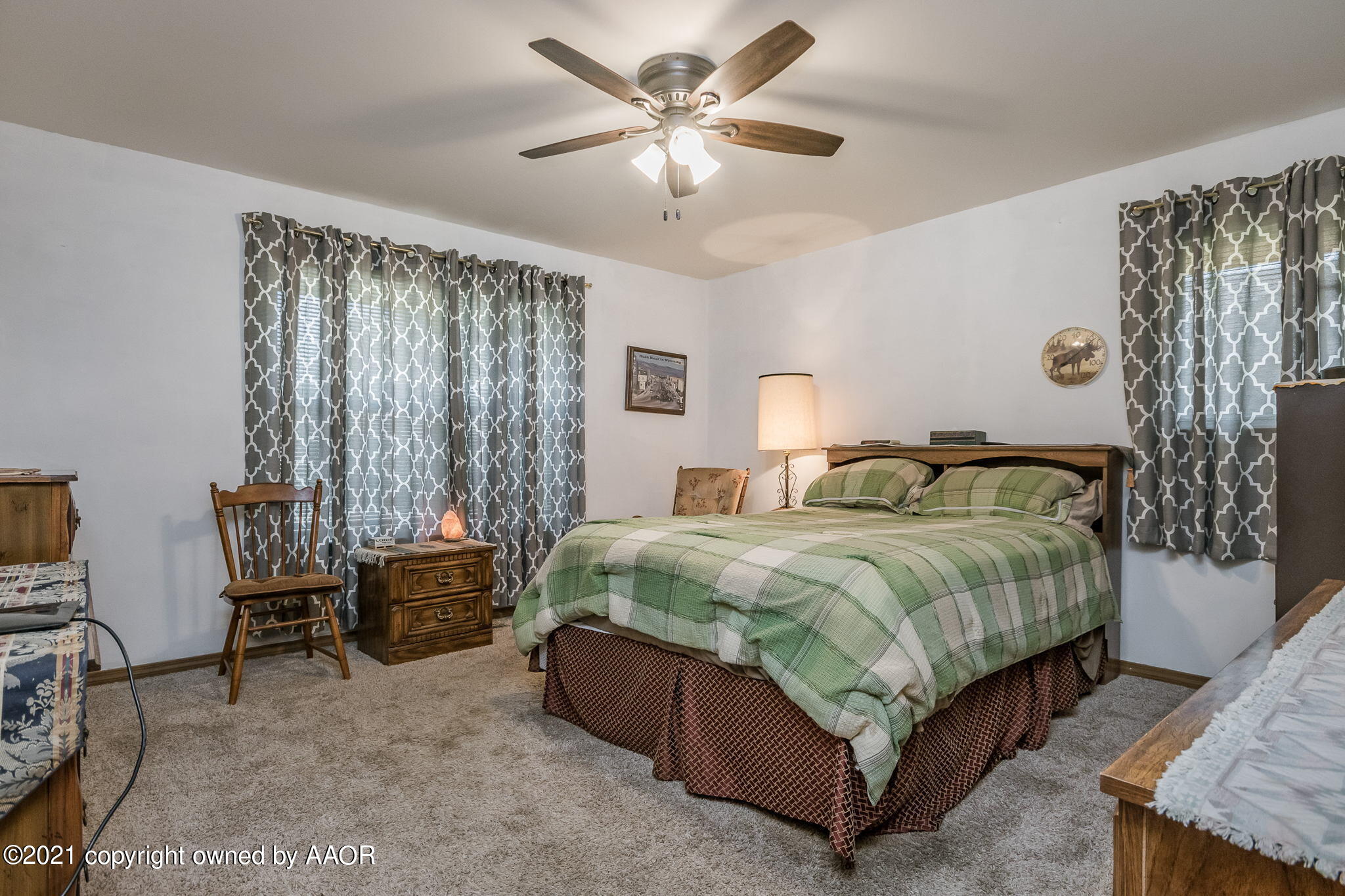 6909 Elmhurst Road Amarillo, TX 79106 - Photo 16 of 23 a bedroom with a bed a chair and a chandelier