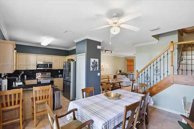 a view of a dining room with furniture a kitchen and chandelier