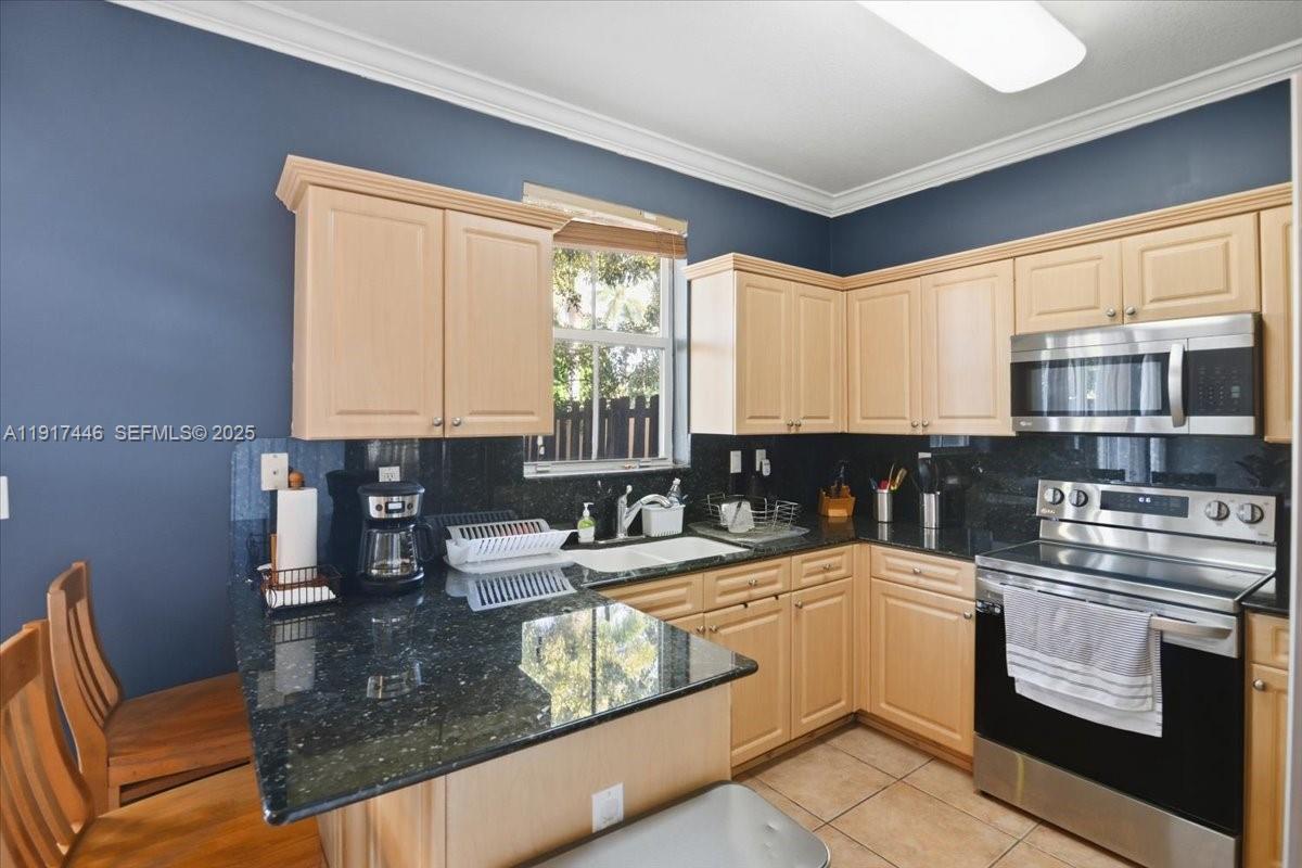 10891 Southwest 88th Terrace Miami, FL 33176 - Photo 13 of 41 a kitchen with stainless steel appliances granite countertop a sink a stove a counter space and cabinets