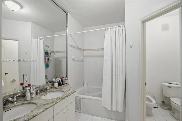 a bathroom with a granite countertop sink a mirror a toilet and shower