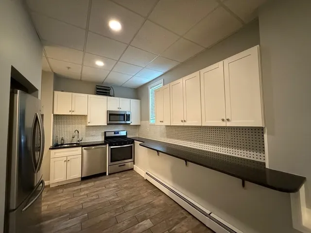 a kitchen with stainless steel appliances granite countertop a sink refrigerator and cabinets