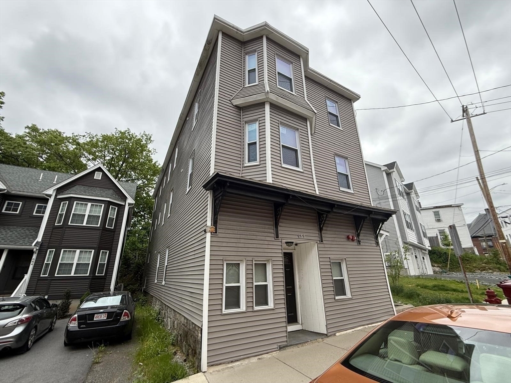690 Lawrence Street, Unit 1 Lowell, MA 01852 - Photo 7 of 8 a front view of a house with a garden