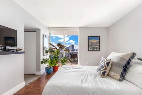 a bedroom with a bed and a flat screen tv