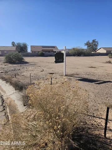 a view of a dry yard with wooden fence