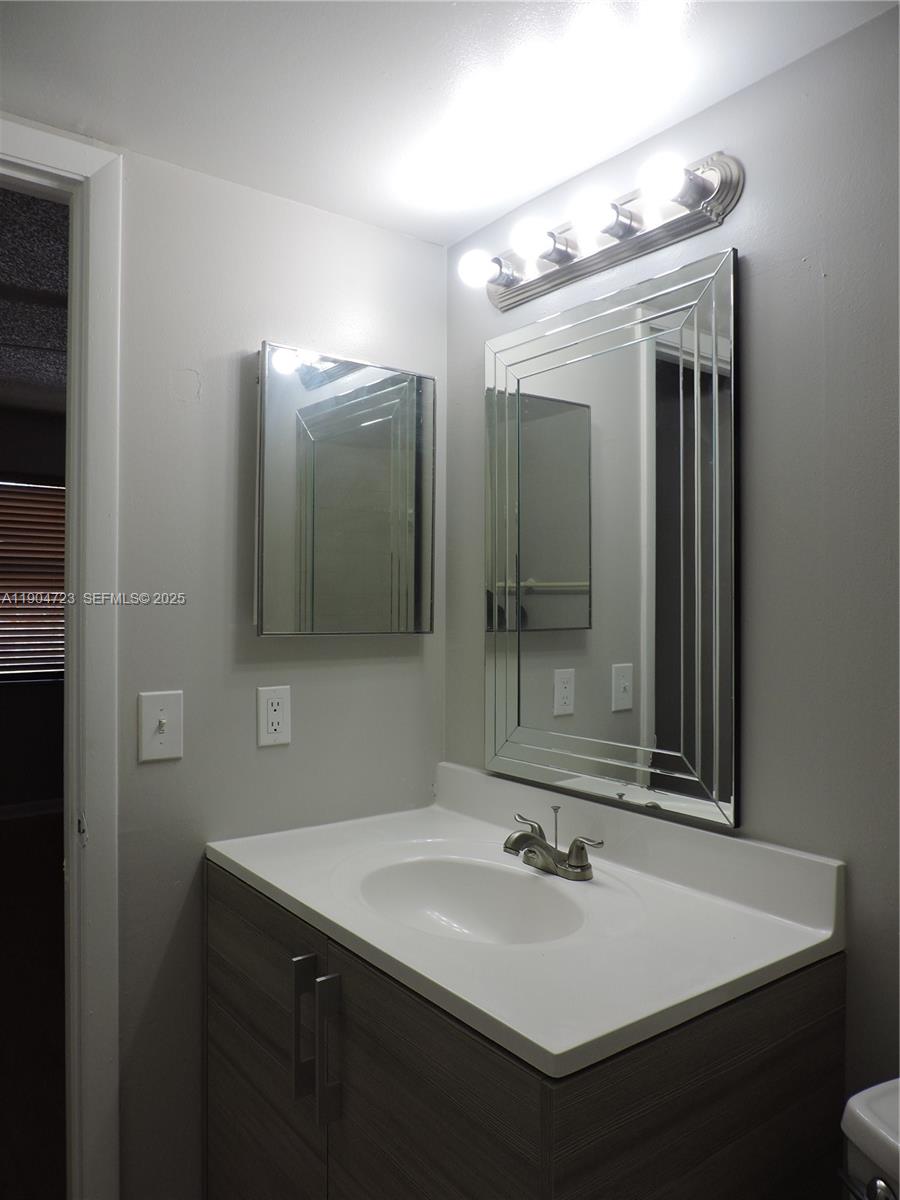 14867 Southwest 104th Street, Unit 2421 Miami, FL 33196 - Photo 14 of 18 a bathroom with a sink and a mirror