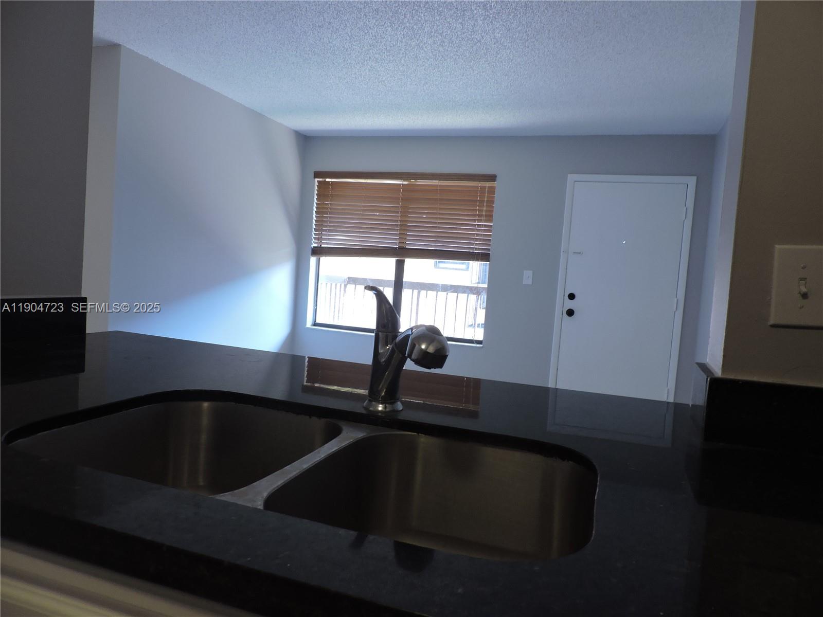 14867 Southwest 104th Street, Unit 2421 Miami, FL 33196 - Photo 4 of 18 a kitchen with a sink and a window