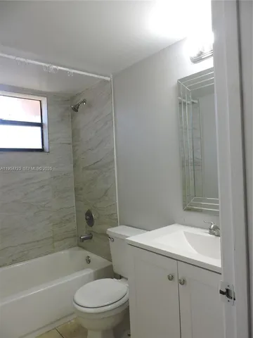 a bathroom with a bathtub shower sink vanity and toilet