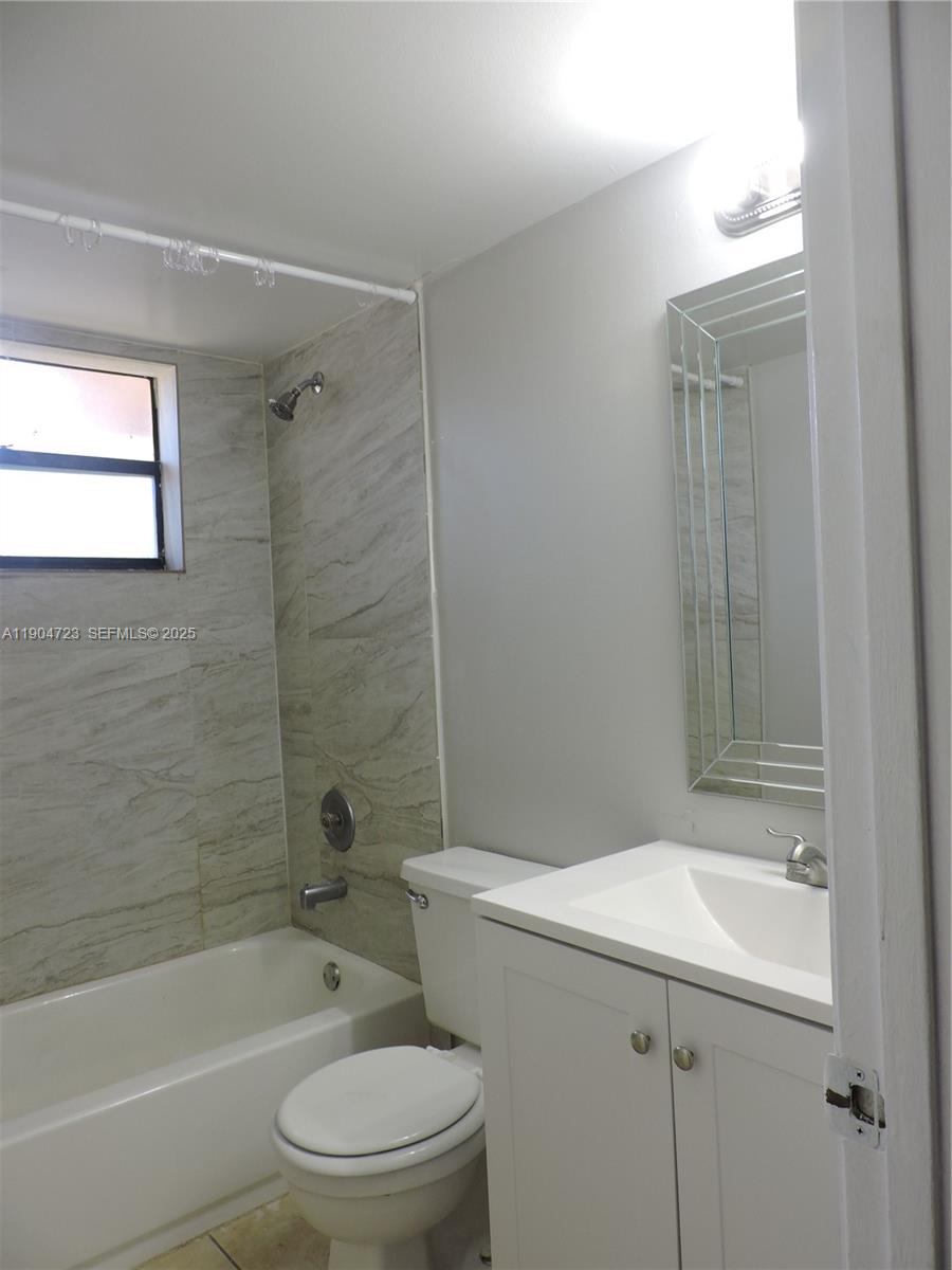 14867 Southwest 104th Street, Unit 2421 Miami, FL 33196 - Photo 8 of 18 a bathroom with a bathtub shower sink vanity and toilet