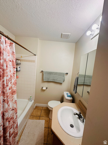 1559 Riverside Avenue, Unit 9 Provo, UT 84604 - Photo 9 of 12 Full bath with vanity, light tile patterned flooring, a textured ceiling, and shower / bathtub combination with curtain