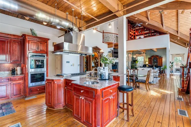 a kitchen with stainless steel appliances granite countertop a stove and a wooden floors
