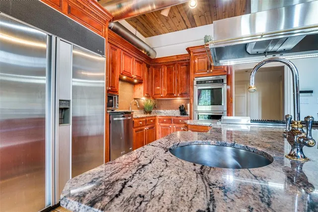 a kitchen with stainless steel appliances granite countertop a sink stove and refrigerator