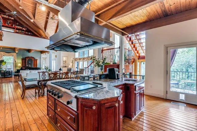 a kitchen with stainless steel appliances granite countertop a stove a sink dishwasher and cabinets with wooden floor