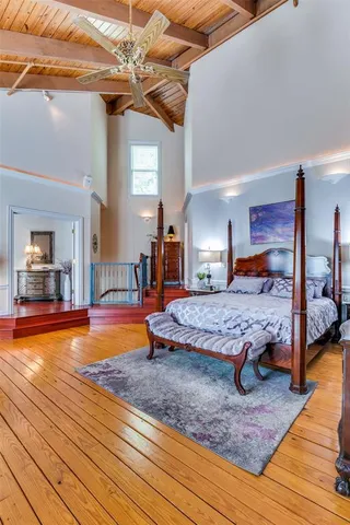 a bedroom with bed and wooden floor