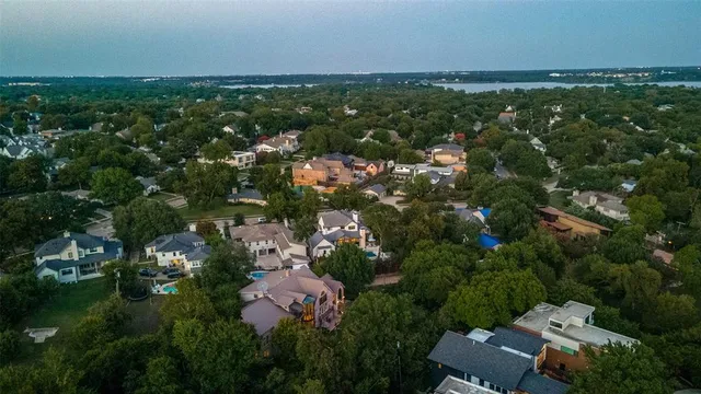 an aerial view of residential houses with outdoor space and trees