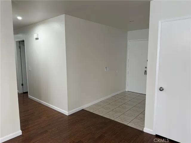 an empty room with wooden floor and entrance