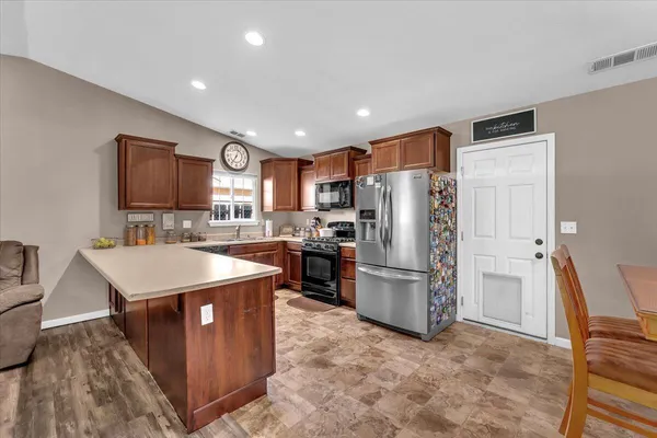 a kitchen with stainless steel appliances granite countertop a refrigerator a sink a stove a microwave and island