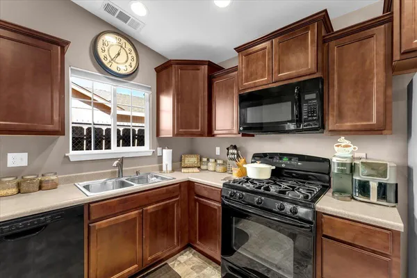 a kitchen with granite countertop a refrigerator stove and microwave